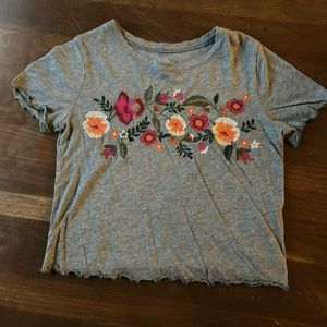 Grey crop top with lettuce trim on the sleeves and bottom. Colorful floral print